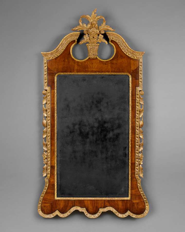 A LARGE GEORGE II PERIOD VENEERED WALNUT AND CARVED GILTWOOD UPRIGHT WALL MIRROR 
